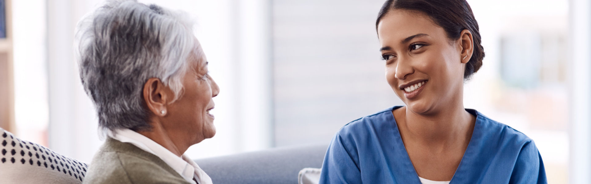 elderly woman and caretaker smiling