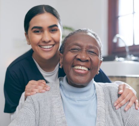 aide and senior woman smiling