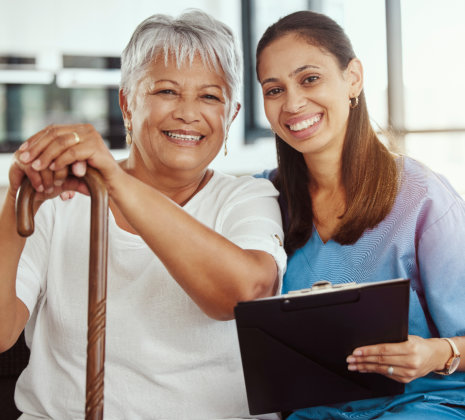 aide and senior woman smiling